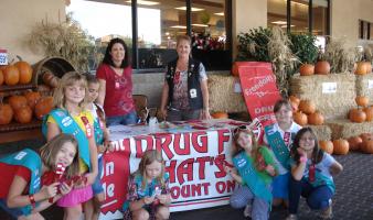 A troop of Junior Girl Scouts promote awareness at a Red Ribbon booth 