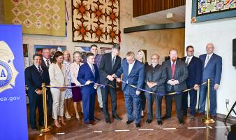 A group of people cut a ribbon, opening a new exhibit.
