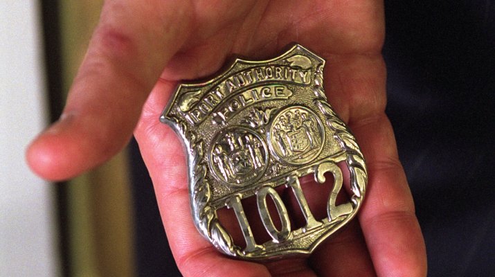 President George W. Bush holds the badge of an NYPD hero who gave his life trying to save others on 9/11. George W. Bush Presidential Library.
