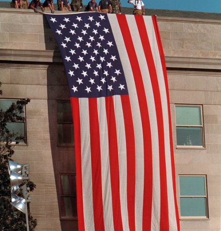 A large American flag hangs from the Pentagon. Flags and flag imagery were everywhere as the nation tried to move forward following the attacks. George W. Bush Presidential Library. 