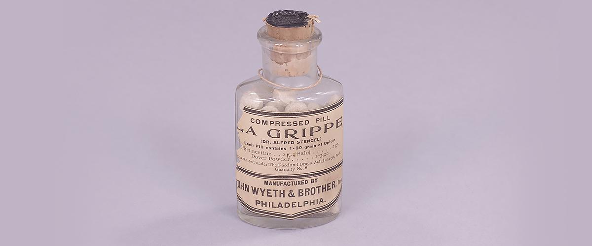   A glass bottle of pills labeled "La Grippe."
