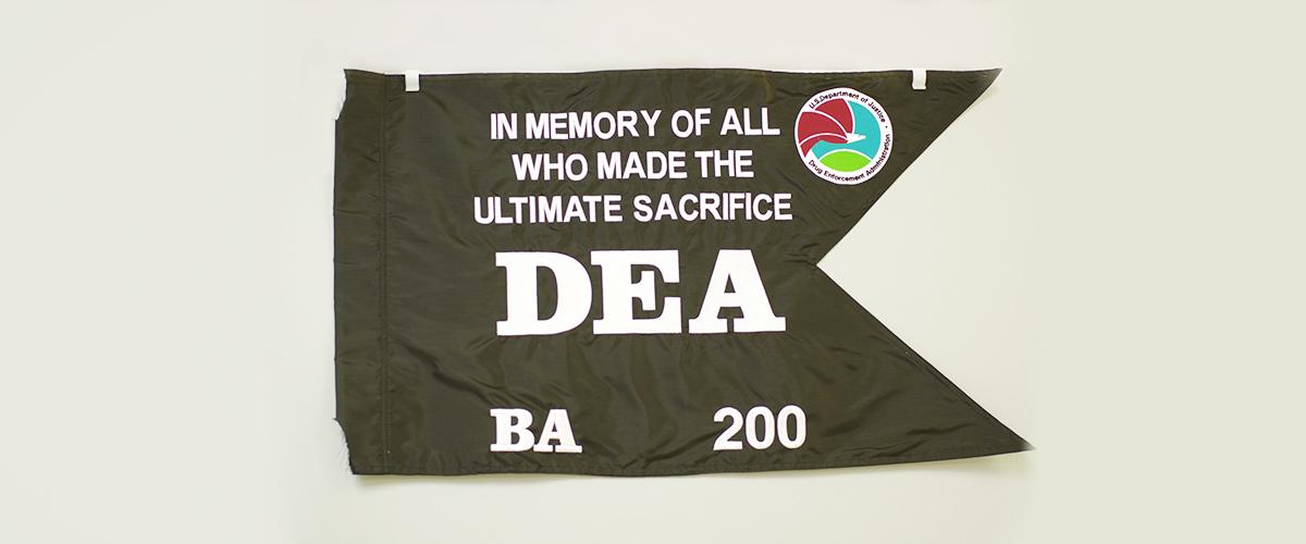 A black swallow-tailed flag with white lettering.