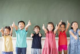 Children with their thumbs up.