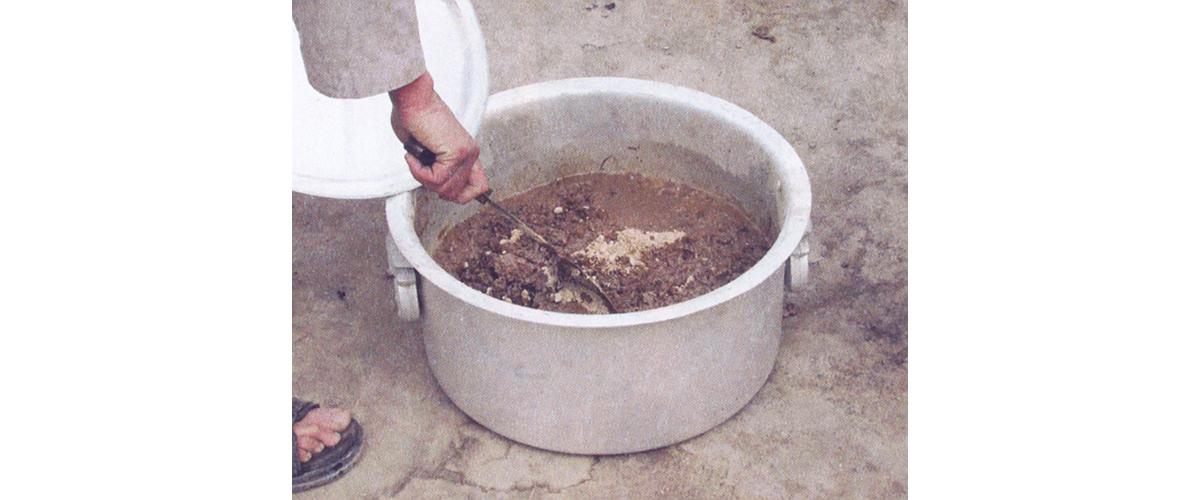 A person stirring a pot of processing heroin