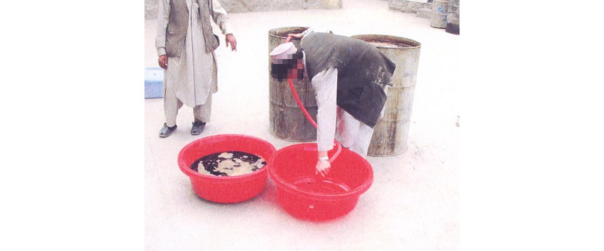 A man siphoning morphine out of red buckets 