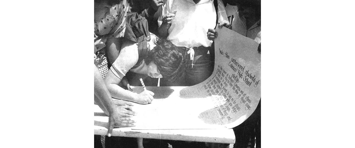 Students at Calexico High School take turns signing a large pledge poster in the late 1980s
