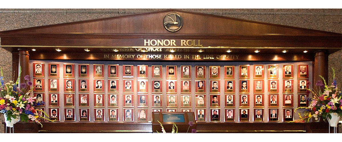 DEA's previous, all-wood Wall of Honor with framed pictures and placeholders of fallen heroes.