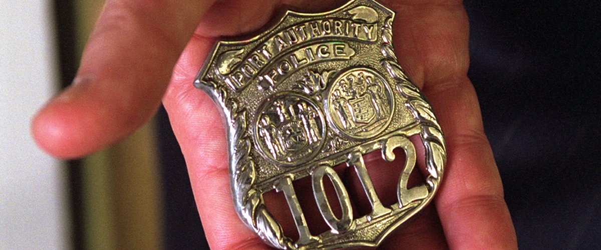 President George W. Bush holds the badge of an NYPD hero who gave his life trying to save others on 9/11. George W. Bush Presidential Library.
