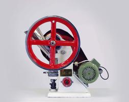 A red, green, and white tablet press.